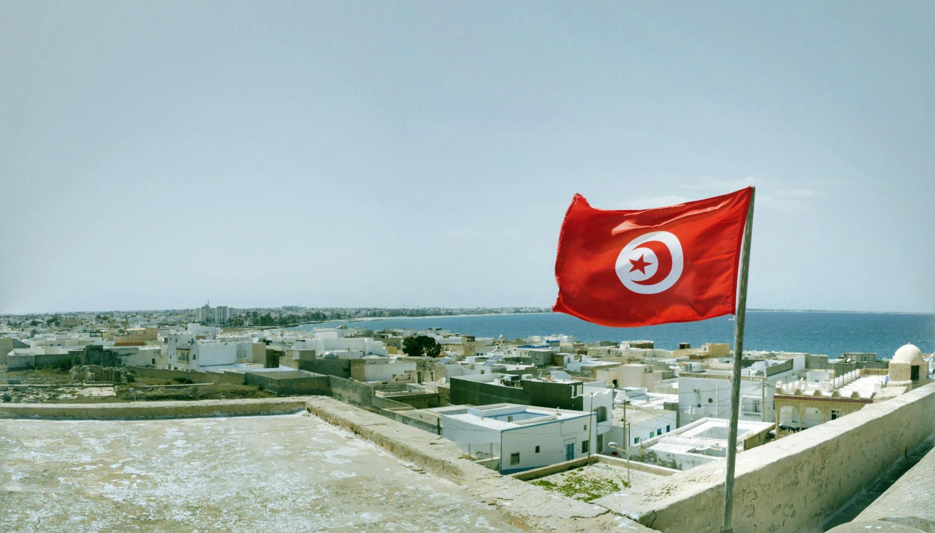 tunisia flag on old waterfront town background